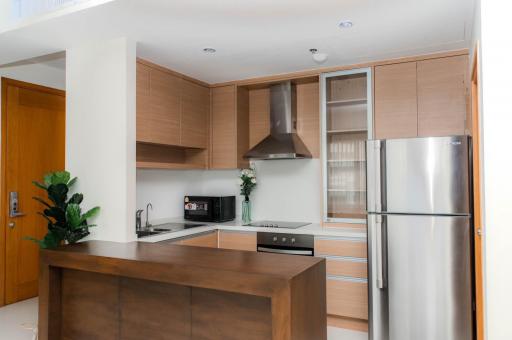 Modern kitchen with wooden cabinets, stainless steel appliances, and island