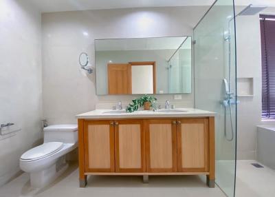 Modern bathroom with wooden cabinets and glass shower