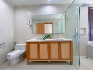 Modern bathroom with wooden cabinets and glass shower