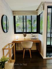 Modern home office interior with a desk, chair, globe, and green shutter window