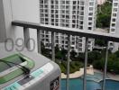 Balcony view overlooking apartment complex with swimming pool