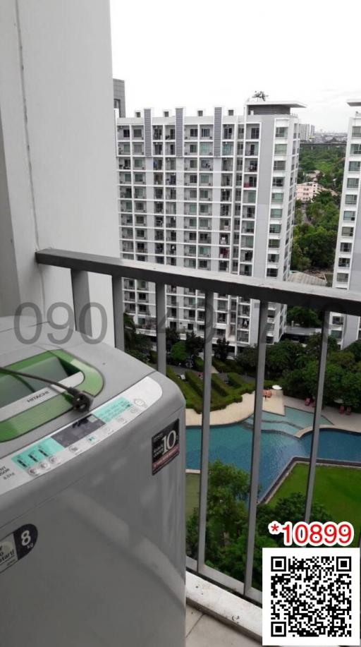 Balcony view overlooking apartment complex with swimming pool