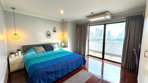 Spacious bedroom with large windows and riverside view