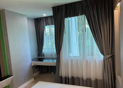 Well-lit bedroom with large windows and modern curtains