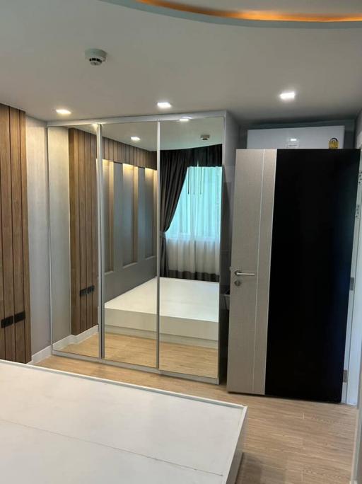 Modern bedroom with mirrored wardrobe and hardwood floors