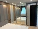 Modern bedroom with mirroring wardrobe doors and sleek interior design