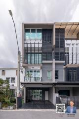 Modern multi-story residential building facade with large windows and a garage