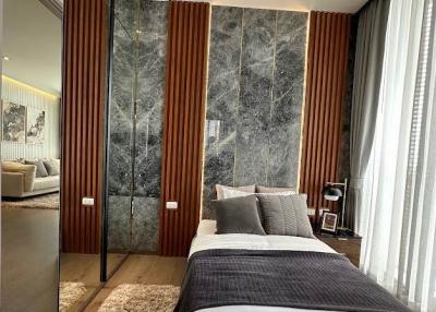 Modern bedroom with marble wall accent and reflective wardrobe doors