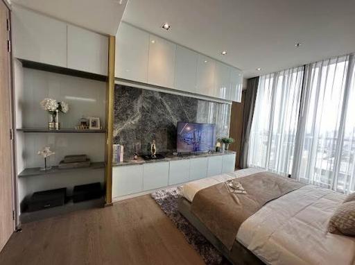 Modern bedroom with an integrated entertainment unit and a city view