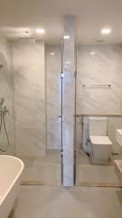 Modern bathroom with glass shower enclosure and marble tiles