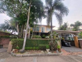 Exterior view of a two-story house with a garden and a carport