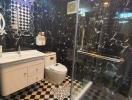 Modern black and white tiled bathroom with glass shower enclosure