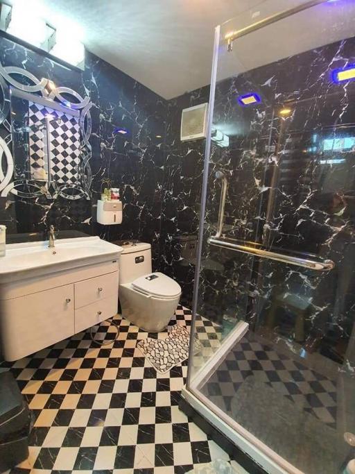 Modern black and white tiled bathroom with glass shower enclosure