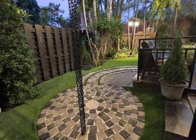 Cozy backyard garden with paving stone pathway and lush greenery