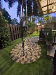 Cozy backyard garden with paving stone pathway and lush greenery