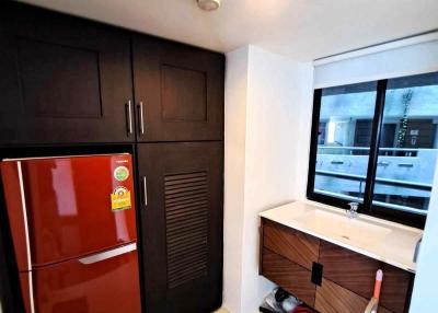 Compact kitchen with a red refrigerator, modern cabinets, and sink