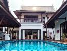 Spacious poolside area with a traditional style building in the background