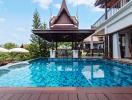 Private swimming pool with a traditional pavilion and modern house exterior