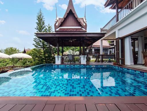 Private swimming pool with a traditional pavilion and modern house exterior