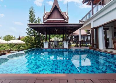 Private swimming pool with a traditional pavilion and modern house exterior