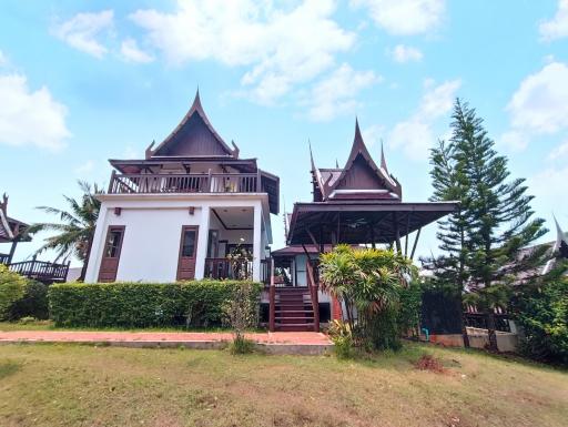 Traditional style house with gabled roofs surrounded by greenery