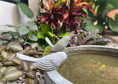 Decorative bird sculpture with surrounding plants in an outdoor patio area