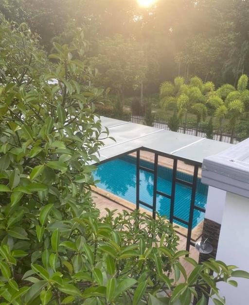 Luxurious poolside with lush greenery at sunset