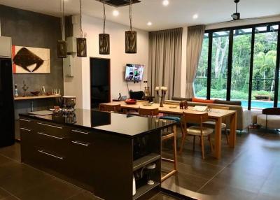 Elegant living room with open-plan dining area, modern furnishings, and ample natural light