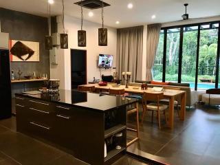 Elegant living room with open-plan dining area, modern furnishings, and ample natural light