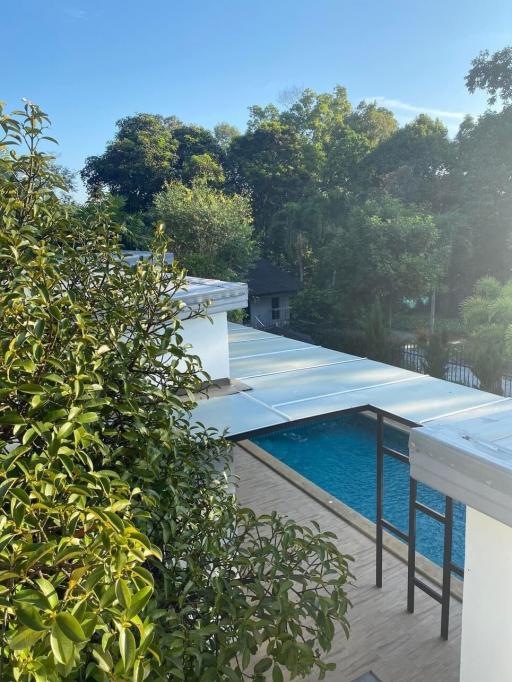 Balcony view overlooking swimming pool and greenery