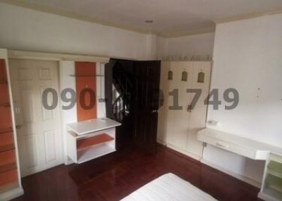 Spacious bedroom with hardwood floors, natural light and ample storage space