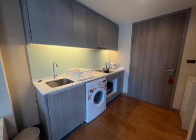 Compact modern kitchen with built-in appliances and wooden flooring