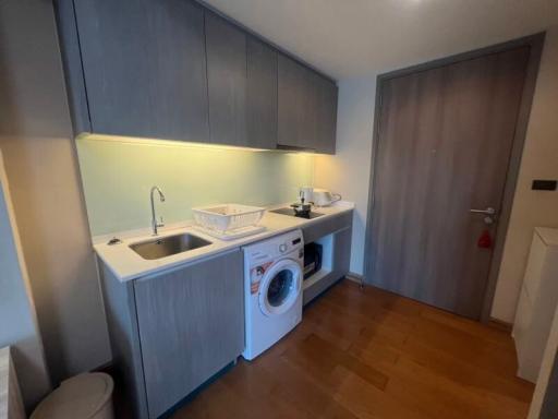 Compact modern kitchen with built-in appliances and wooden flooring