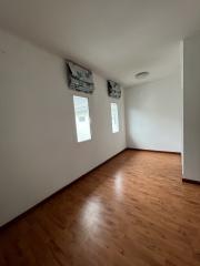 Spacious bedroom with hardwood floors and natural light