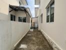 Narrow outdoor alleyway between residential buildings