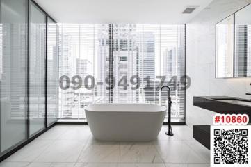 Modern bathroom with freestanding tub and city view