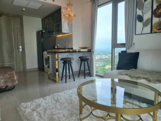 Contemporary open-plan living room with kitchenette, showcasing modern furniture and a scenic view