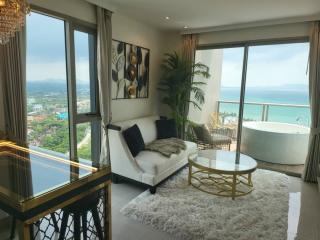 Spacious living room with ocean view, modern furniture, and an elegant bathtub