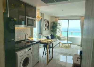 Modern apartment interior with an open plan kitchen, living area and a balcony with ocean view