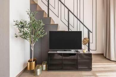 Modern living room interior with television and decorative staircase