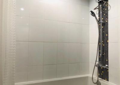 Modern bathroom with white tiles and shower system