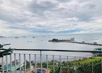 Scenic sea view from a high-rise balcony with overhanging greenery