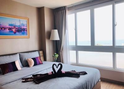 Modern bedroom interior with large windows and ocean view