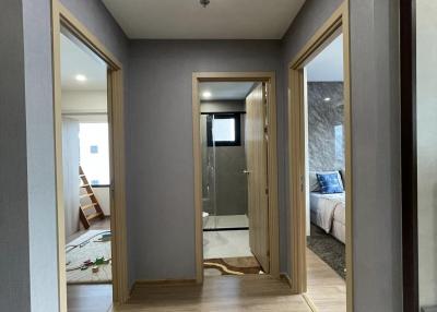 Bright corridor with wooden floors and multiple doorways leading to rooms