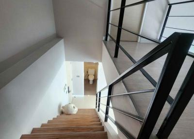 Modern wooden staircase with black metal railing in a residential home