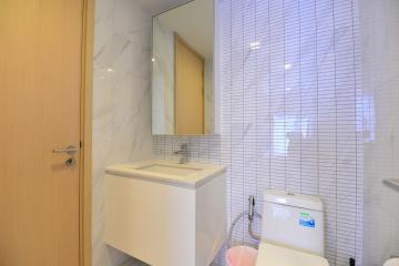 Modern bathroom with marble tiles and wooden cabinet