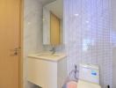 Modern bathroom with marble tiles and wooden cabinet