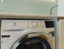 Front-loading Electrolux washing machine in a home laundry room