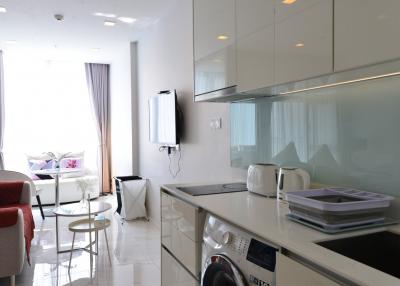 Modern kitchen with white cabinets adjacent to a cozy living area