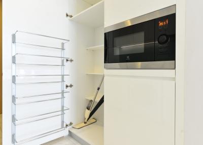 Modern kitchen with white cabinetry and built-in microwave oven